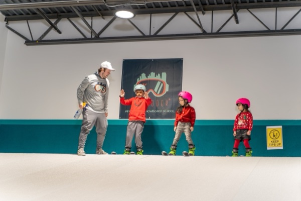 Instructor high-fiving young skier at Shredder holiday camp