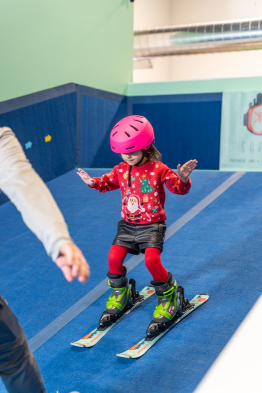 Young girl in pink helmet practicing pizza stance at Shredder Chicago