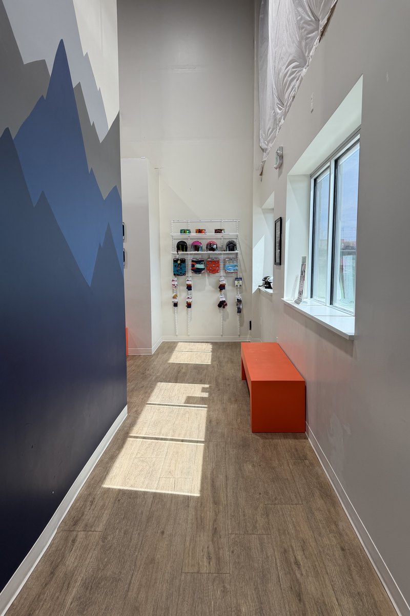 The retail wall at Shredder Lafayette, goggles and helmets racked beside the daylight windows