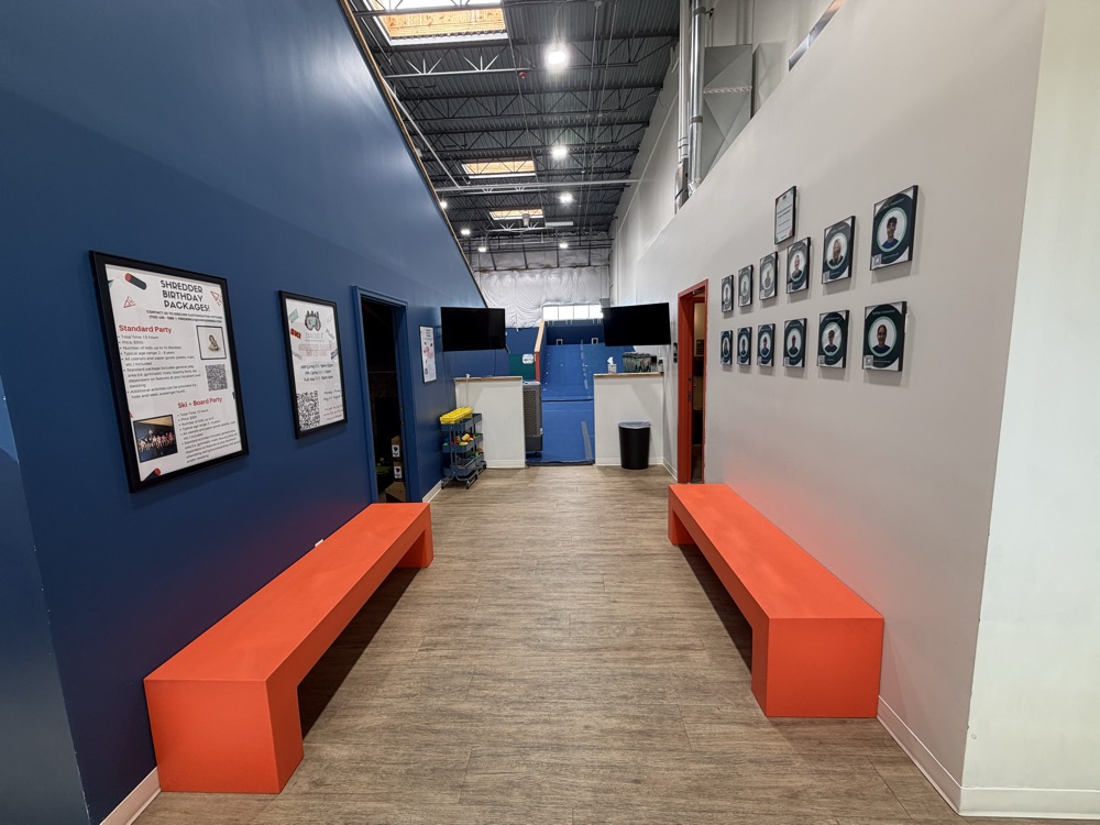 Shredder Lafayette lobby with orange benches and instructor photos on wall