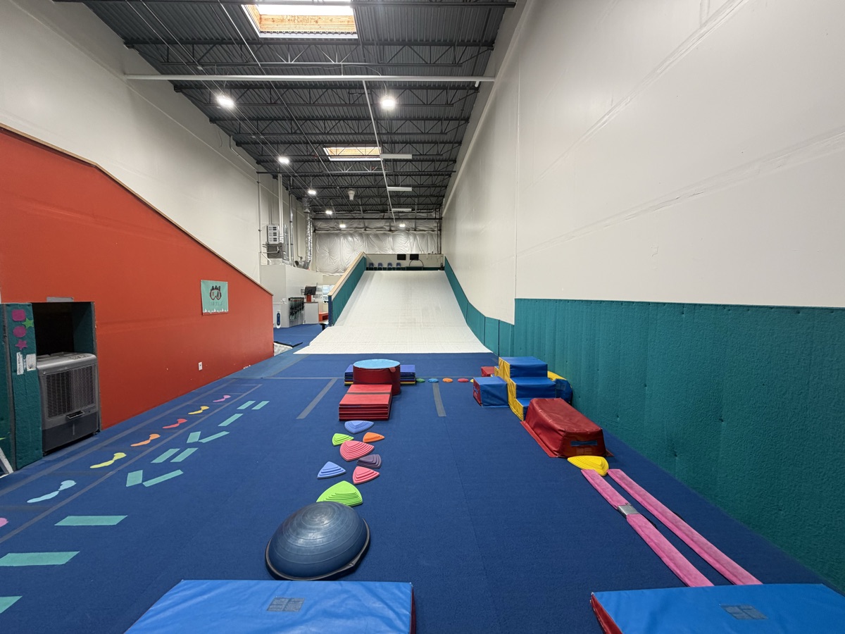 Indoor slope and training zone at Shredder Lafayette with colorful obstacles