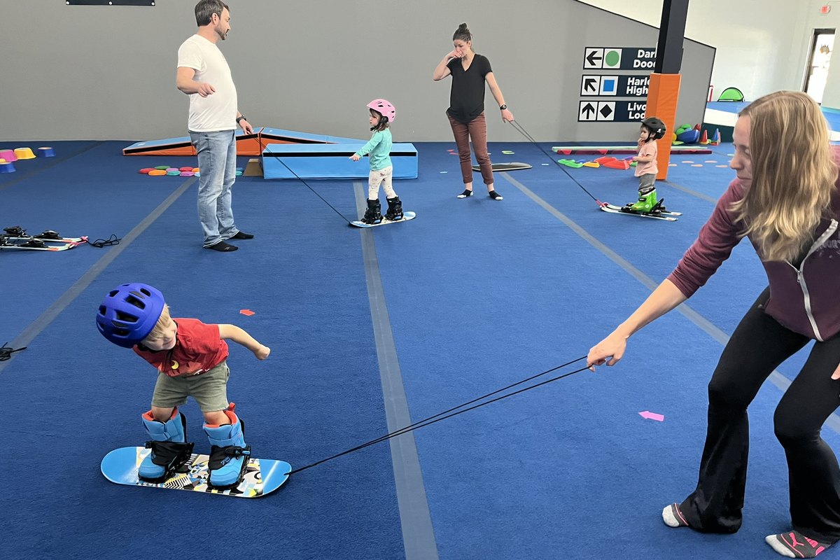 Three coaches working with four children across the training floor at Shredder Livonia