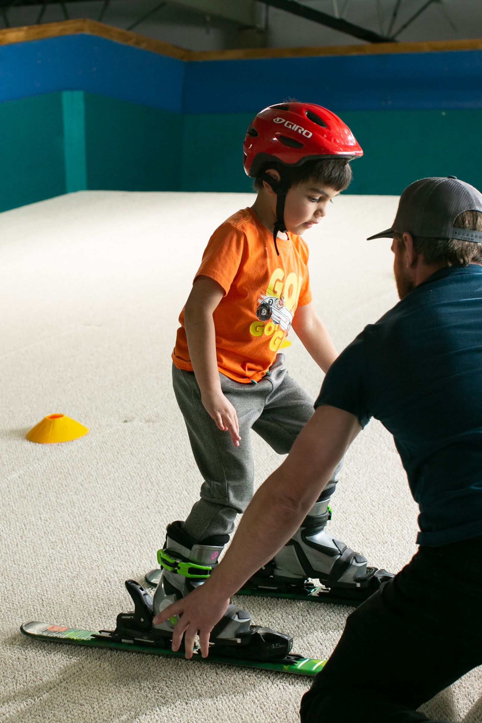 A Shredder coach kneels beside a young skier during a one-on-one private lesson