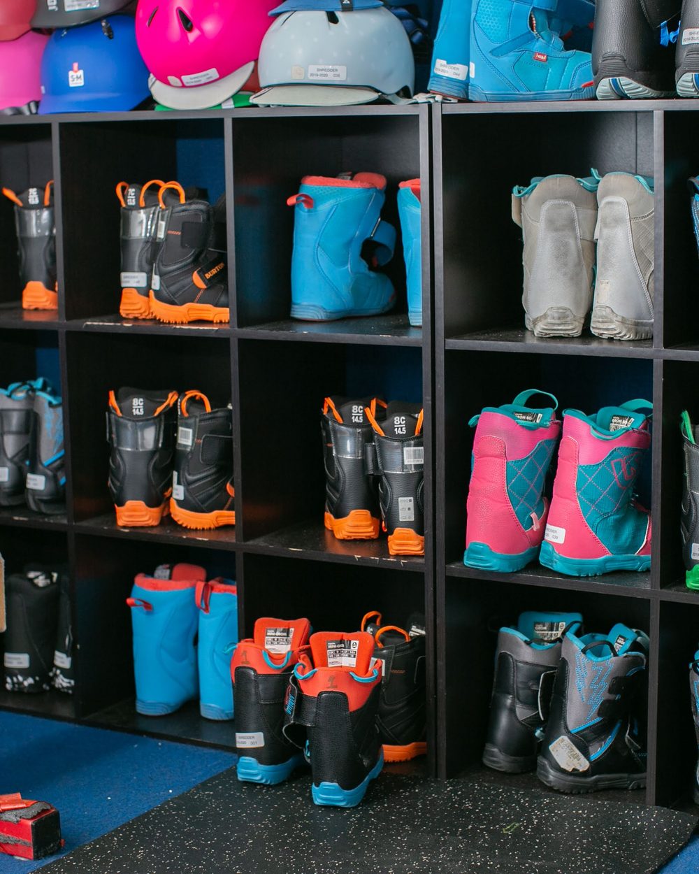 Ski and snowboard boots sorted by size in the fitting cubbies