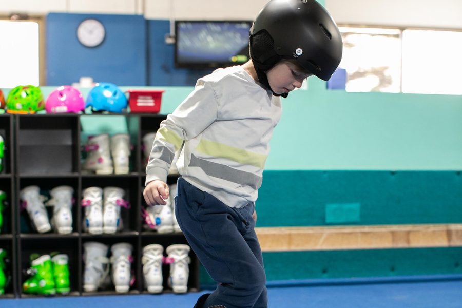 A young skier moving across the indoor slope