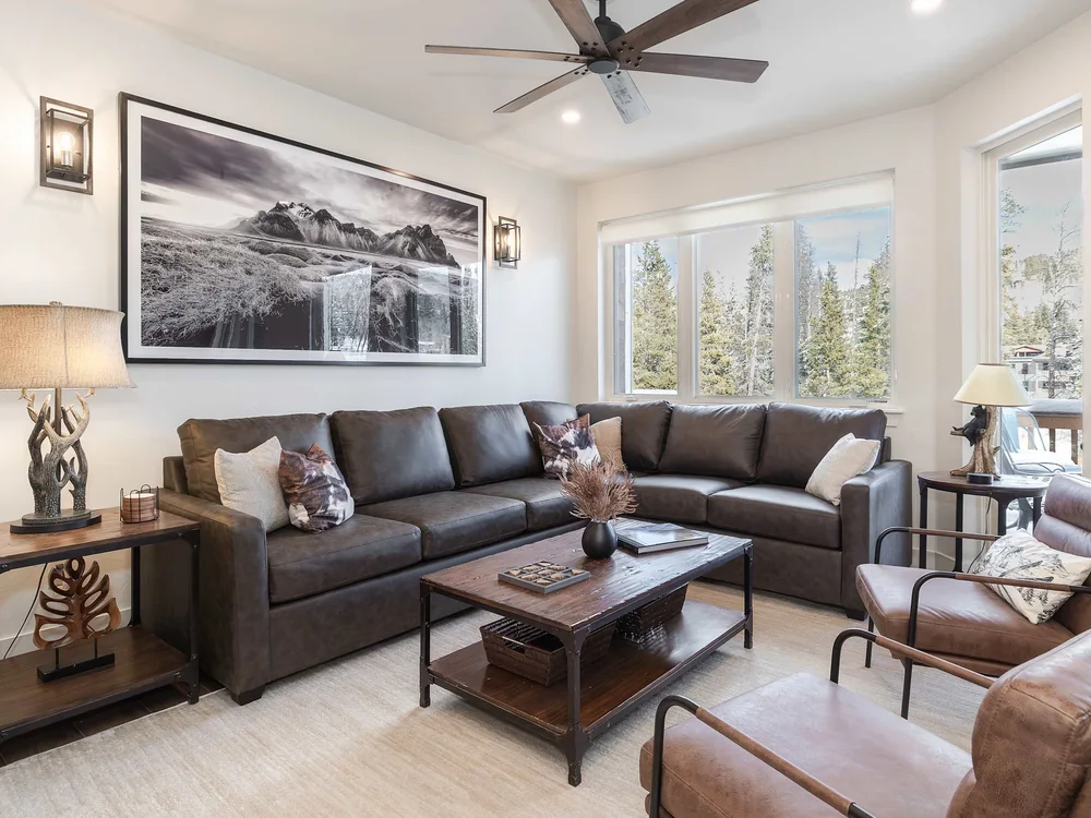 The Shred Haus living room, with two sofas and windows onto the trees