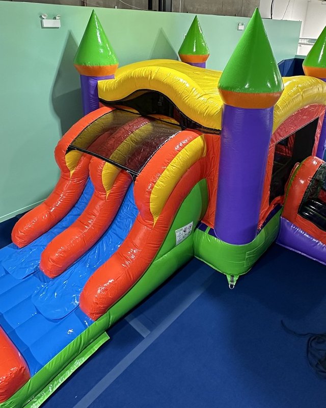 An inflatable bounce castle with a double slide on the play floor