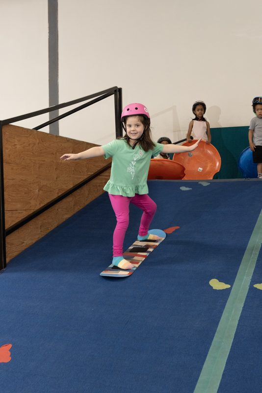 A young rider linking turns on a board at Shredder Wheat Ridge